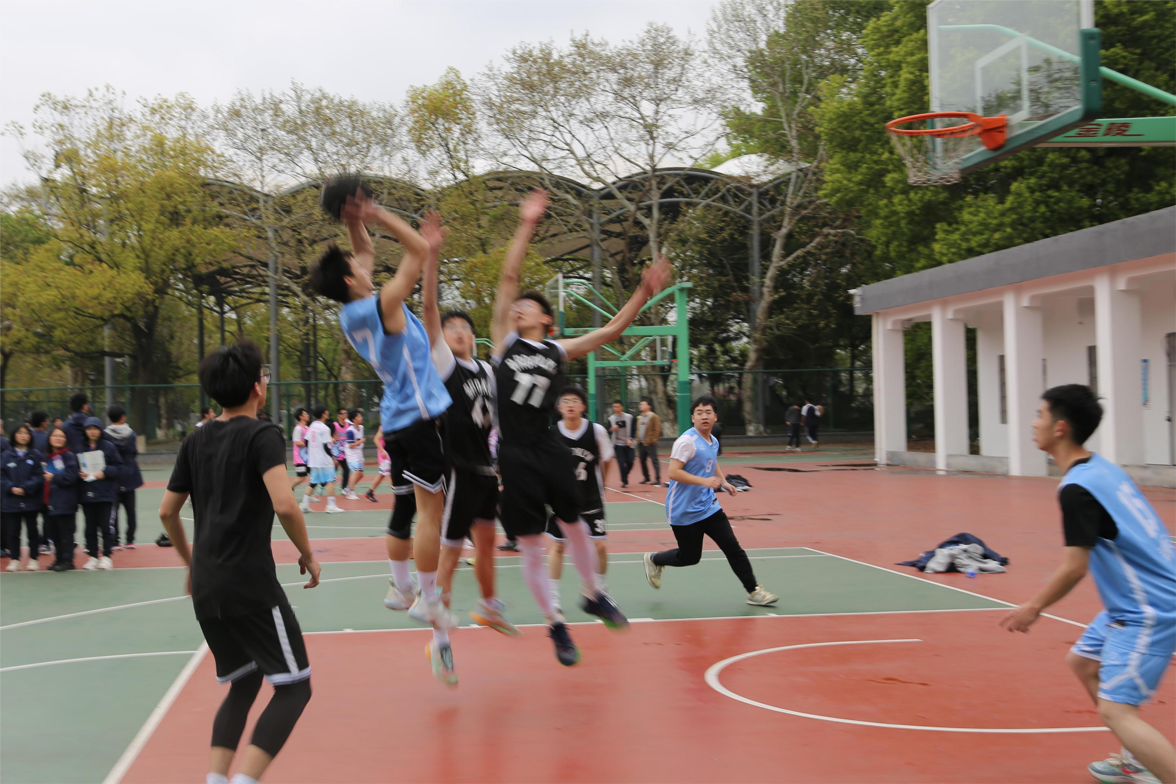 A basketball player driving toward the basket while defenders close in