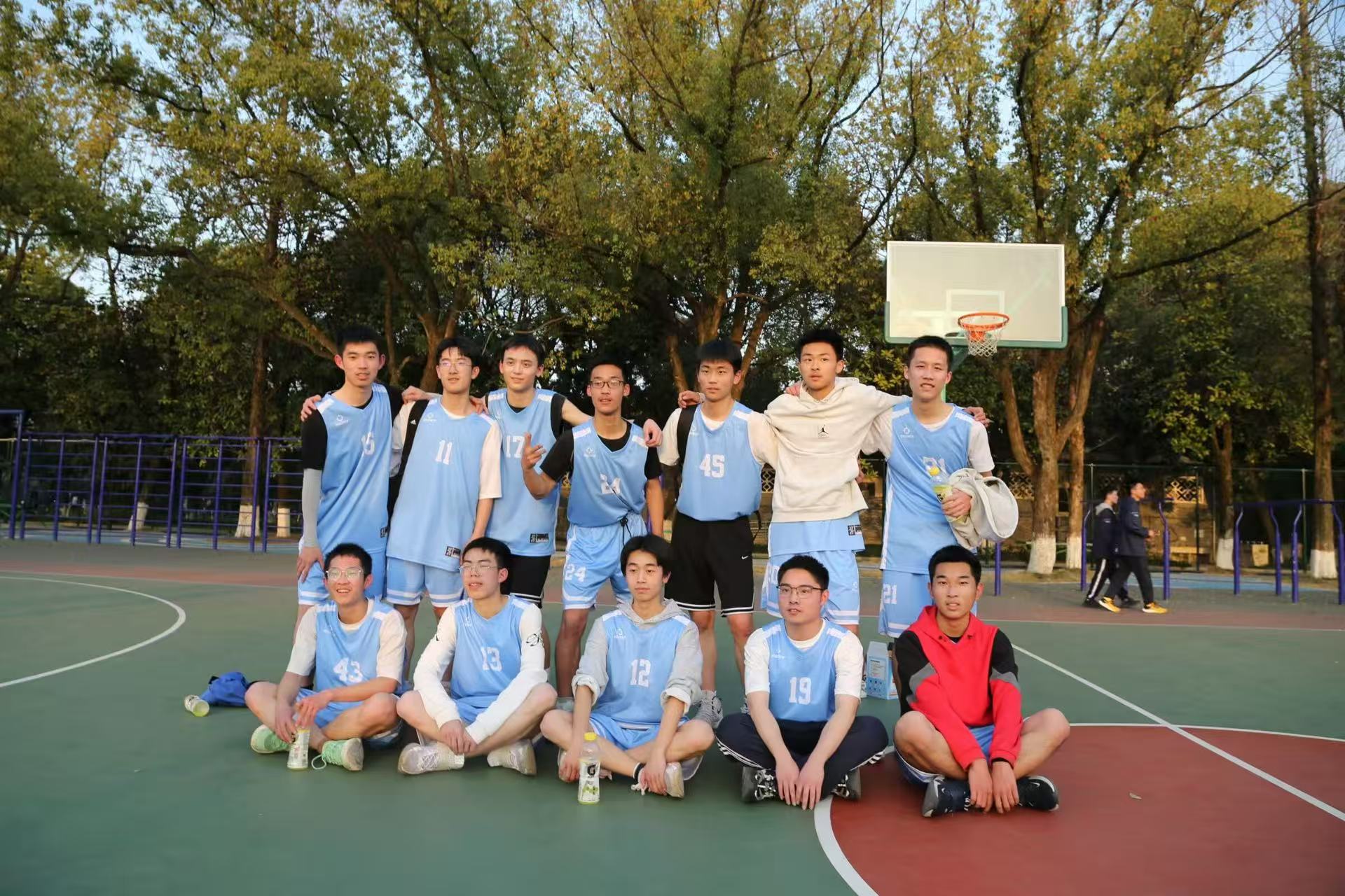 A basketball team posing together on an outdoor court