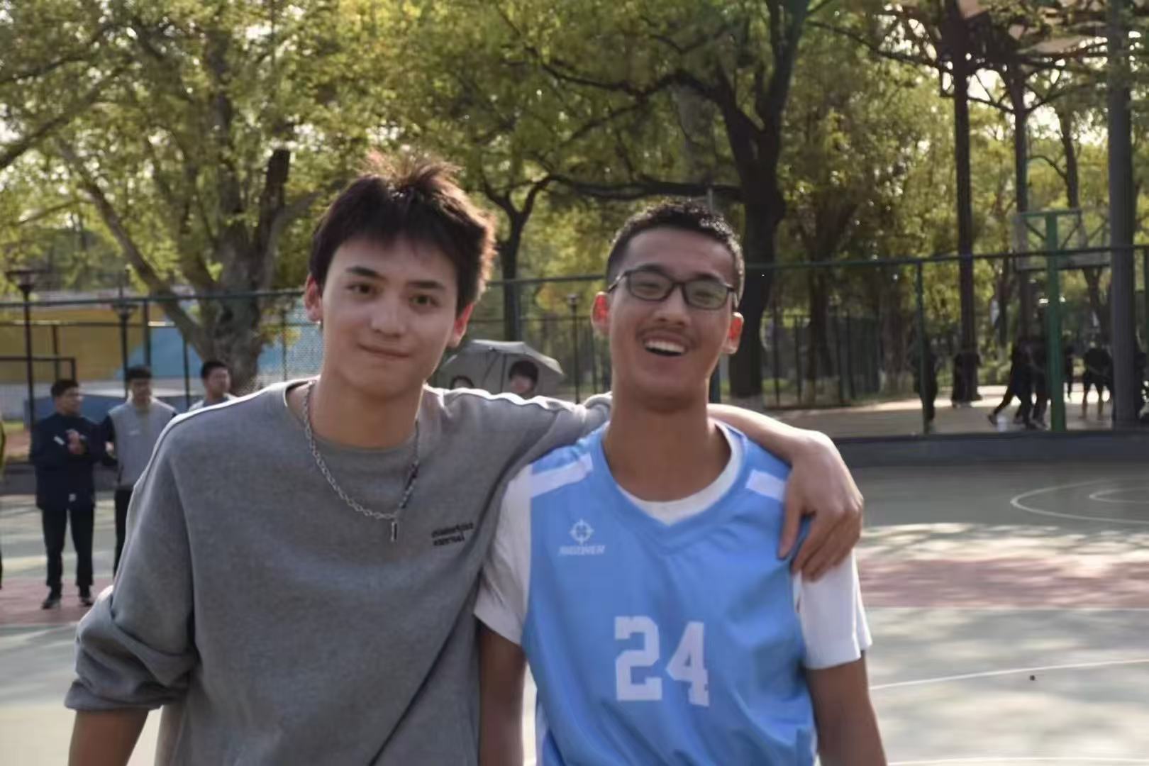 Two teammates standing together on an outdoor basketball court